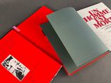 two red books sitting on top of each other on top of a table