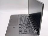 a silver laptop with a black keyboard on a white surface