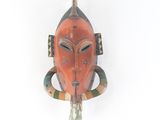une image d'un masque en bois accroché au mur