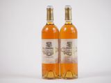 deux bouteilles de vin posées l'une à côté de l'autre sur une surface blanche