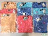 six different colored shirts are wrapped in plastic on a table