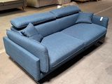 a blue couch with pillows on it in a warehouse