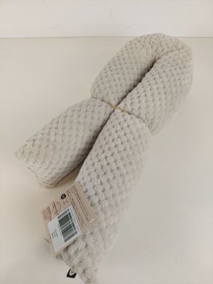 deux mitaines blanches en tricot posées sur une surface blanche, avec une étiquette de prix