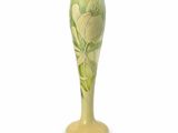 un vase vert orné d'une fleur sur fond blanc