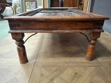 a wooden table with a glass top on a wooden floor