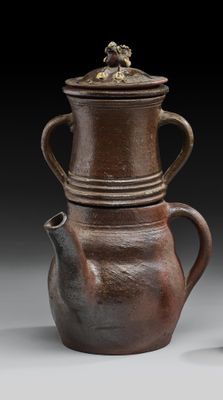une paire de vases marron avec couvercles et anses, posés sur un fond gris