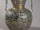 a silver vase with a chain hanging from it