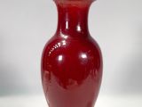 une lampe rouge posée sur une table blanche
