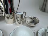 a white table with silver dishes and silverware on it