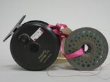 a reel and a spool with a pink ribbon on a white background