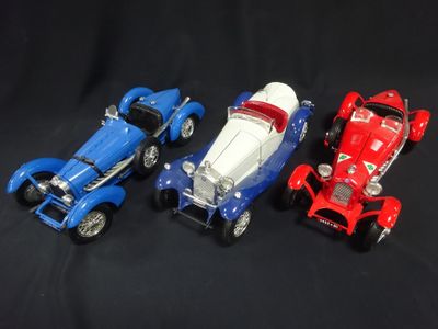 three toy cars sitting next to each other on a black background