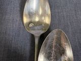 two spoons that are sitting on a table