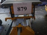 une table sur laquelle est posé un panneau, au milieu d'une pièce