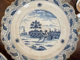 a blue and white plate with a picture of a landscape on it