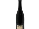 a bottle of wine sitting on top of a white surface
