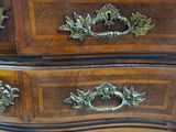 an image of a wooden dresser with ornate handles