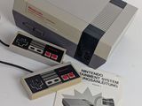 an old nintendo game system sitting on a table next to a book