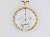 a gold pocket watch hanging on a white wall