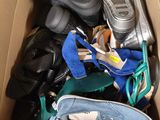 plusieurs paires de chaussures dans une boîte en carton posée sur le sol