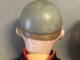 a doll that has a helmet on it ' s head