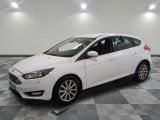 a white ford focus is parked in a room with a checkered floor