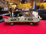 an antique brass plate with two candles on it on a red table