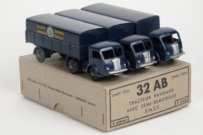 four toy trucks sitting in a box on a white surface