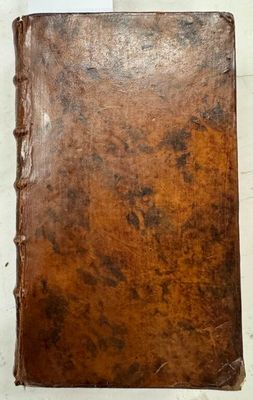 un vieux livre à la couverture en cuir marron posé sur une table