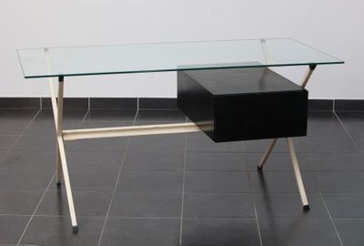 un bureau en verre surmonté d'un tiroir noir