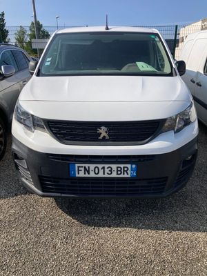 la camionnette blanche est garée dans le parking à côté d'autres voitures