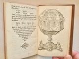someone is holding an open book with a drawing of a sundial on it