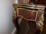 a red and gold table with a mirror on top of it