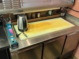 an image of a kitchen with a counter with a pizza on it