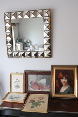 a table with pictures and a mirror on top of it