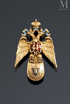an image of a gold eagle broochle with blue and red stones