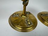 two gold candlesticks with a bird on them