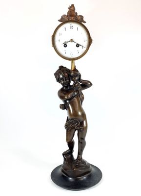 a statue of a man holding a clock on a pedestal