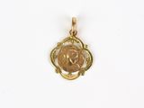 a small gold pendant with a coin in the center