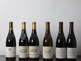 several bottles of wine are lined up on a wooden table
