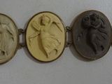 six oval carved cameos of women and men on a white wall