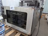 un micro-ondes argenté posé sur une palette dans un entrepôt