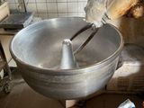 a large metal bowl with a mixer on it in a kitchen