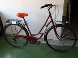 un vélo rouge garé dans une pièce au sol vert