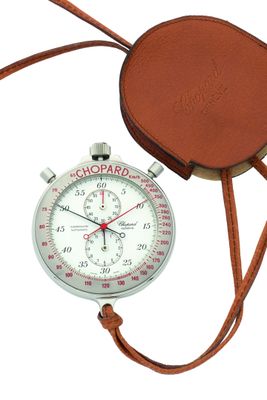 un bracelet en cuir marron entourant une montre de poche sur fond blanc