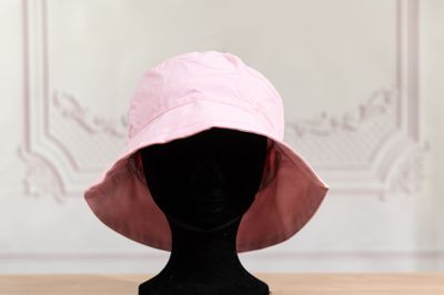 pink bucket hat on a mannequin head on a wooden table