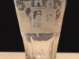 un verre à shot posé sur une table, sur fond noir