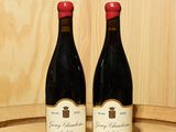 deux bouteilles de vin posées sur un tonneau en bois