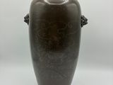 un vase brun avec une anse sur fond blanc