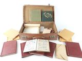 a suitcase filled with books and papers on a white surface