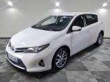 La Toyota Corolla blanche est garée dans une pièce dont le sol est en damier.